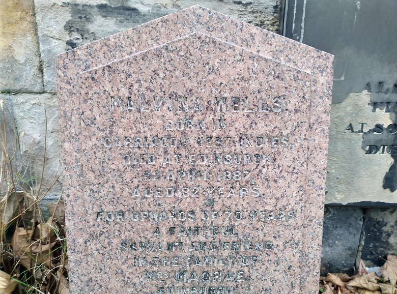 A modest gravestone with largely faded inscriptions 