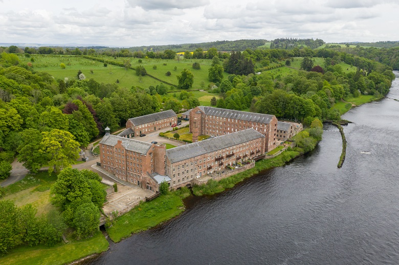 An aerial view of a large riverside mill complex