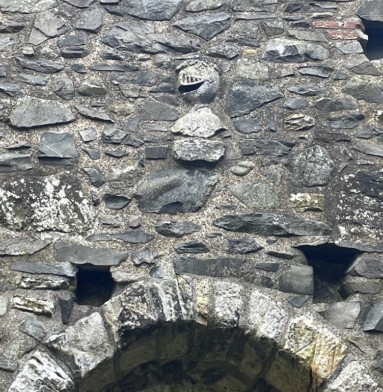 A stone wall featuring a carving of a knight's helmet in profile.