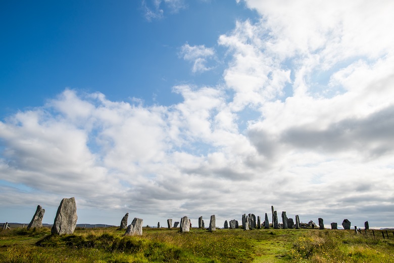 Clouds gathering above a large and impressive group of standing stones, of various shapes and sizes