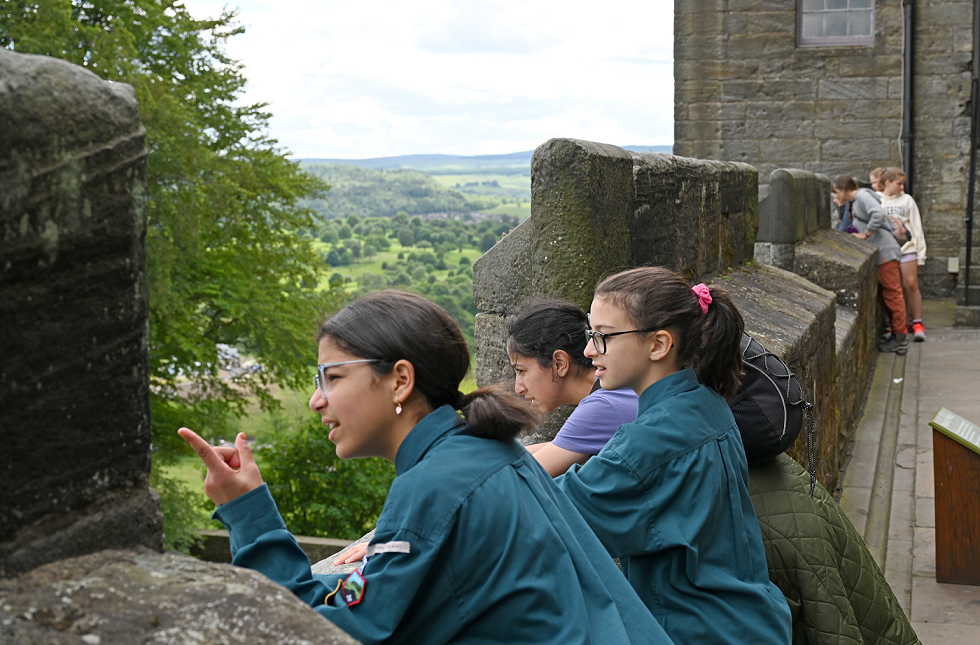 A group of girls from Edinburgh's Muslim Scouts looking over a castle wall on their visit to Stirling Castle.