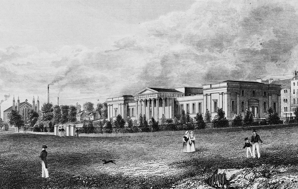 A historic engraving of a grand school building with a columned facade. A handful of figures are walking in parkland in front of the school and a church and some factory chimneys can be seen in the background.