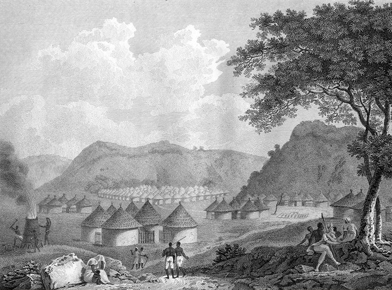An engraving which depicts the village of Kamalia. It shows clusters of well-kept round houses with thatched conical roofs, nestled between hills. On the left, BLack men tend a furnace of some sort. In the foreground a number of Black figures are depicted going about their daily business.