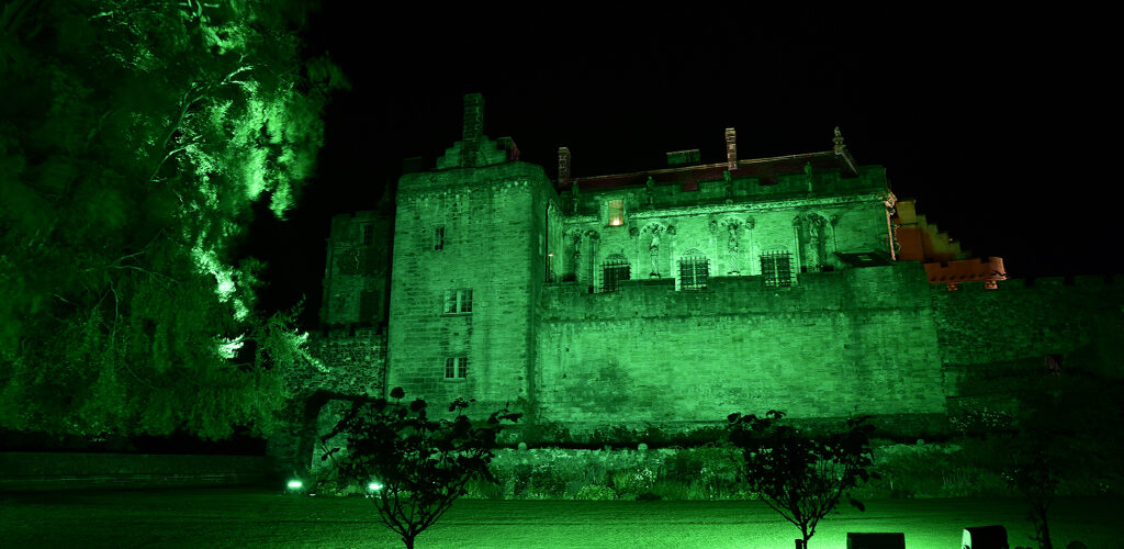 old castle lit in green by floodlights