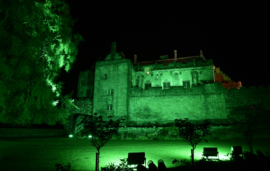 old castle lit in green by floodlights