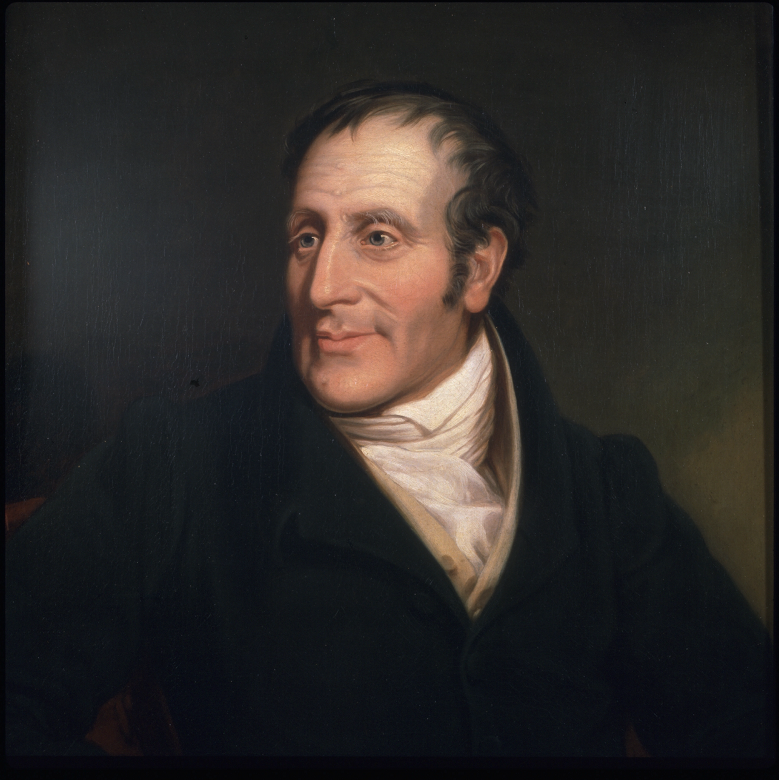 A portrait of Henry Bell wearing a black jacket. He has thinning brown air, prominent features and what seems to be a friendly, happy appearance.