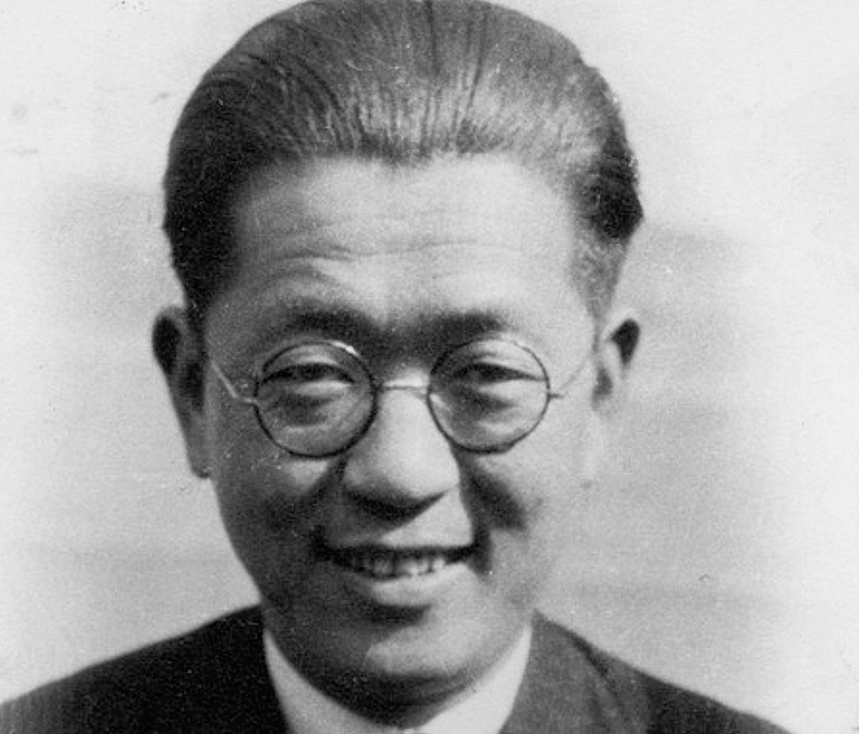 Close up photo of Chiang Yee. He wears glasses and smiles at the camera.