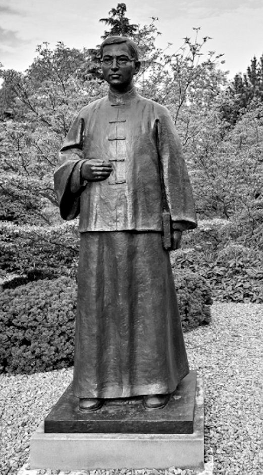 A large statue of Dr Kuan Huang inside a garden
