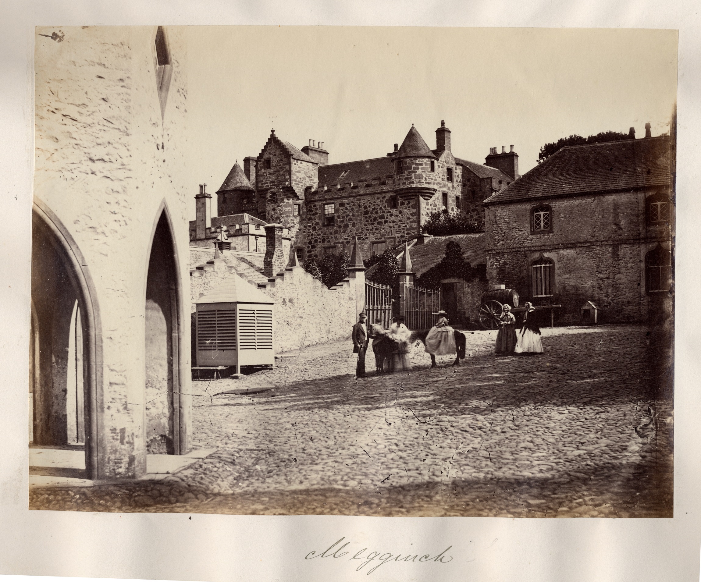 A black and white archive photo of the castle courtyard. There are people standing in the courtyard.
