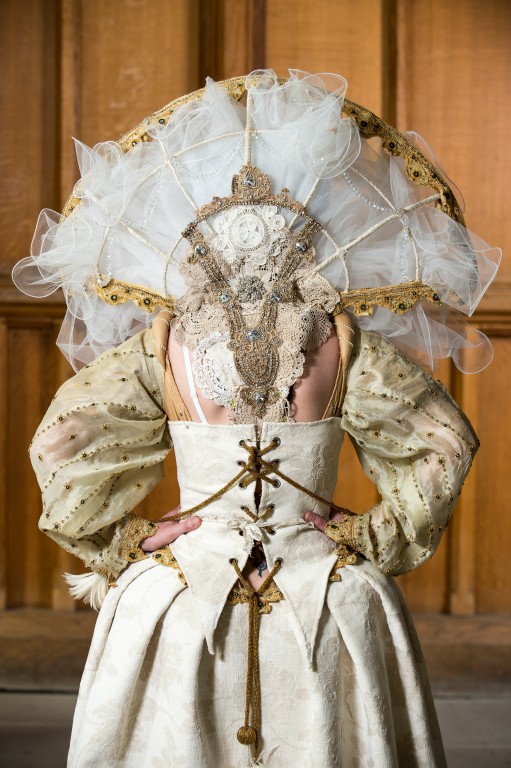 A woman wearing reenactment clothing showing the back of the dress. 