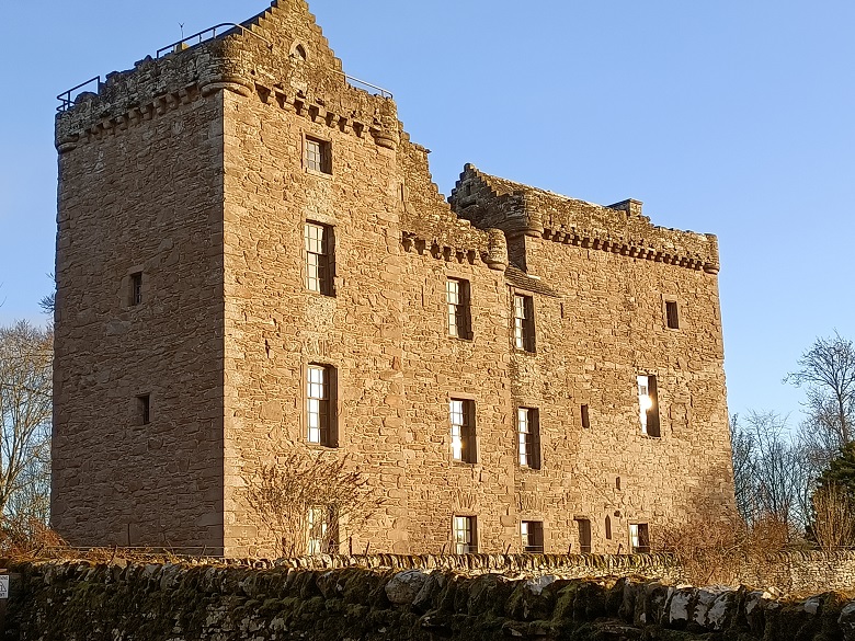 Huntingtower Castle is a medieval castle made up of three square towers joined together. They're around 4 storeys tall. There are battlements around the top.