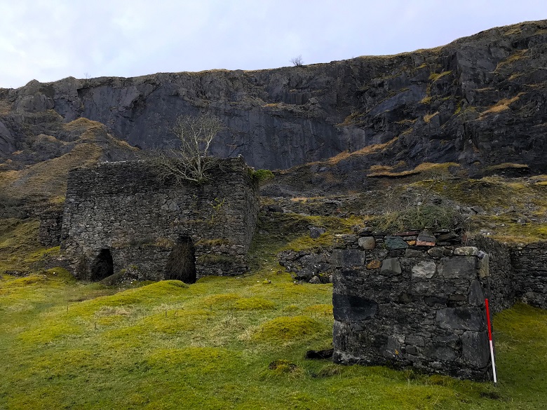 Two ruined kilns in the shadow of an abandoned quarry, which has left a significant grey scar on the landscape. 
