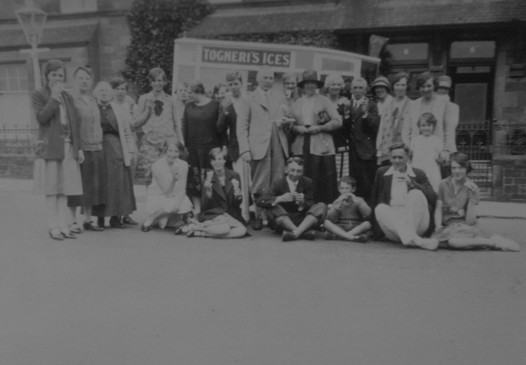 A black and white archive photo of a group of people standing in front of an ice cream van