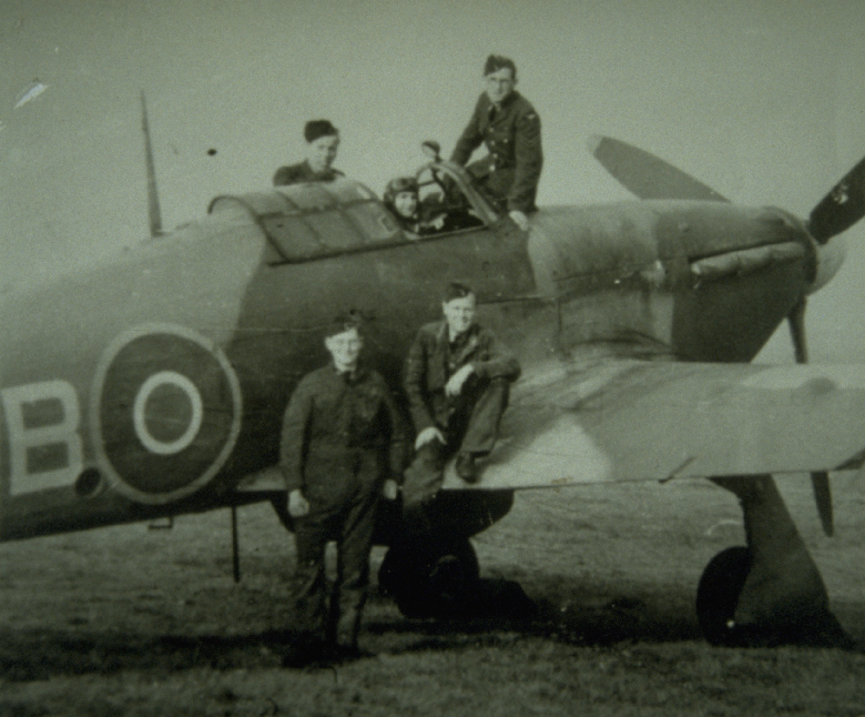 A black and white photo of a Second World War air crew posing with their fighter plane