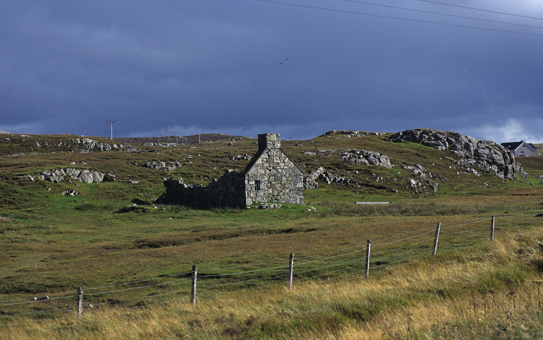 A ruined stone house surrounded by land which was once farmed