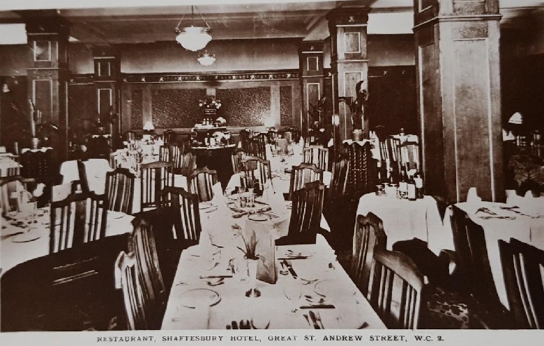 An archive image of a hotel dining room with tables formally set with tablecloths, white napkins and lots of cutlery. 