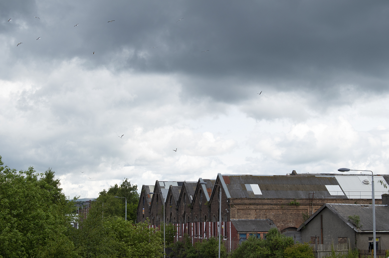 Grey skies above a large and historic factory building in Glasgow