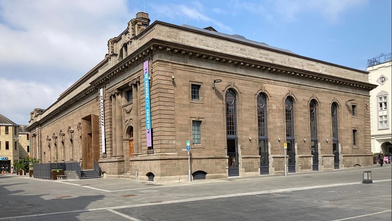 The exterior of Perth Museum. Five symmetrical archways dominate one side of the building, each containing an ornate window and doorway. 