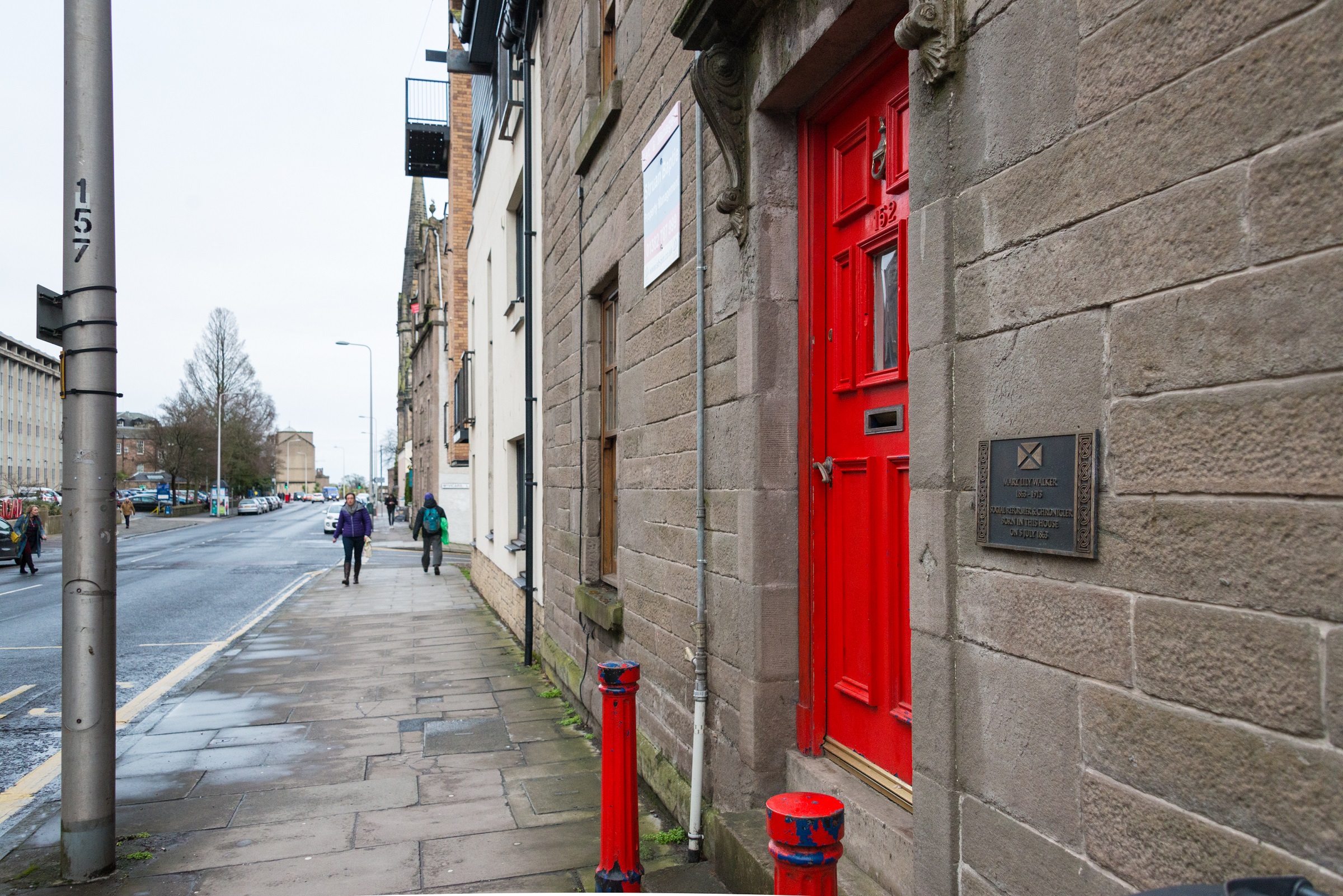 Image of a red door and a building and the adjacent street. It's 152 Perth Road, Dundee, Mary Lily Walker's birthhouse.