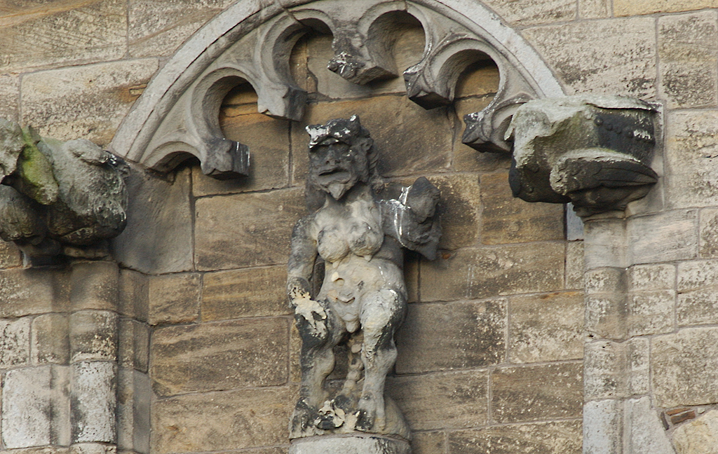 stone carving of a figure with horns and grimacing face