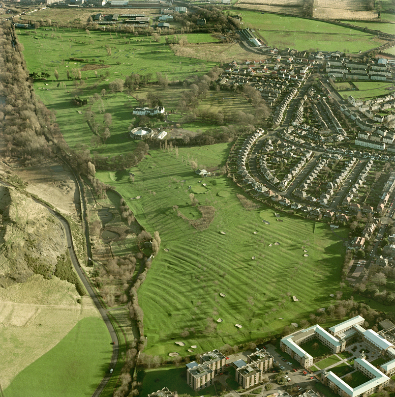 An aerial view of a golf course where the remains of agricultural activity can be made out. 