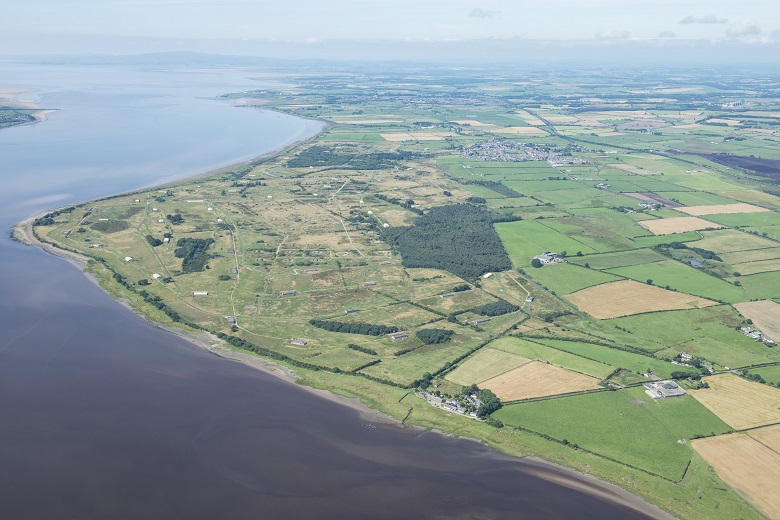 An aerial photo showing a huge former factory site flanked by the Solway Firth on one side and farmland on the other.