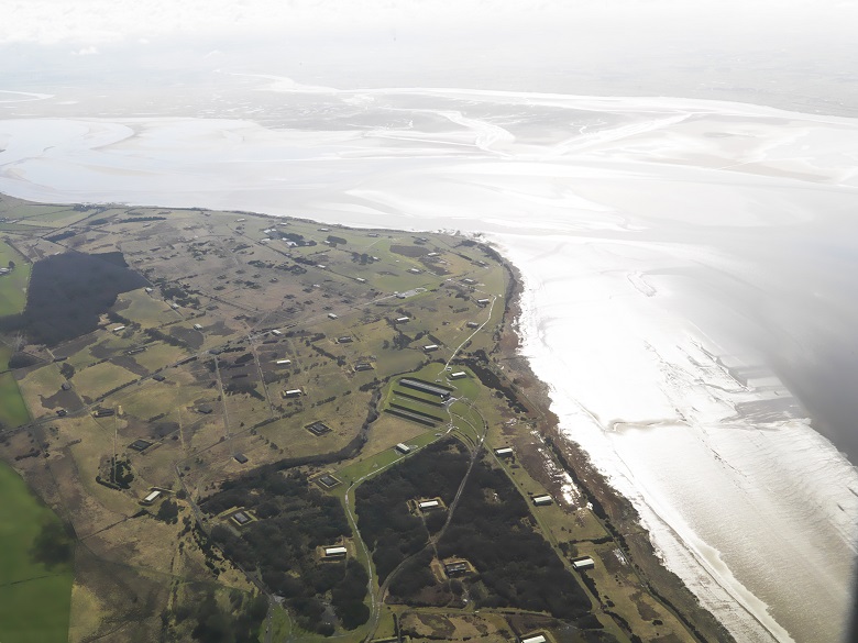 An aerial view of an extensive former factory site beside the sea