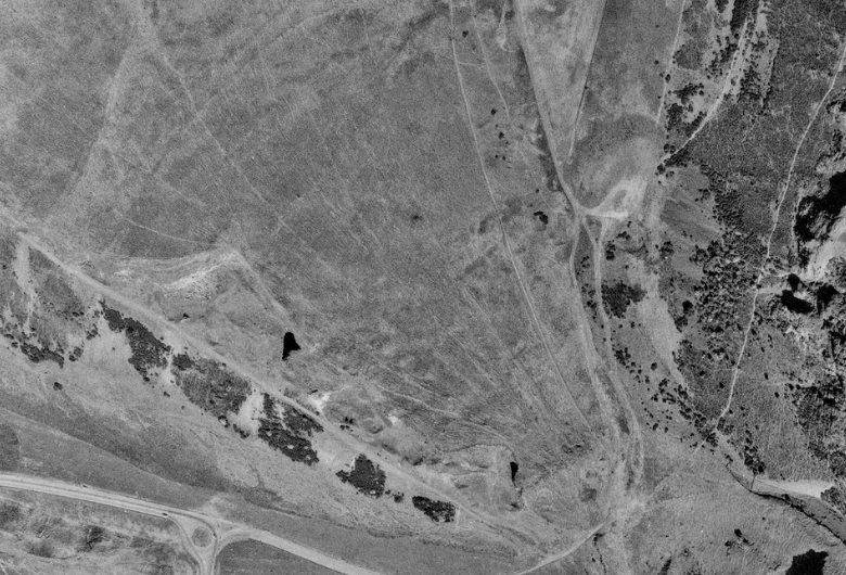 Aerial view from directly above the Crags. The road passes along the top left corner of the image. It's hard to make out the Crags because they appear flat taken directly above but they run parallel to the road. ALong the top are some paths but they are small and not that defined.