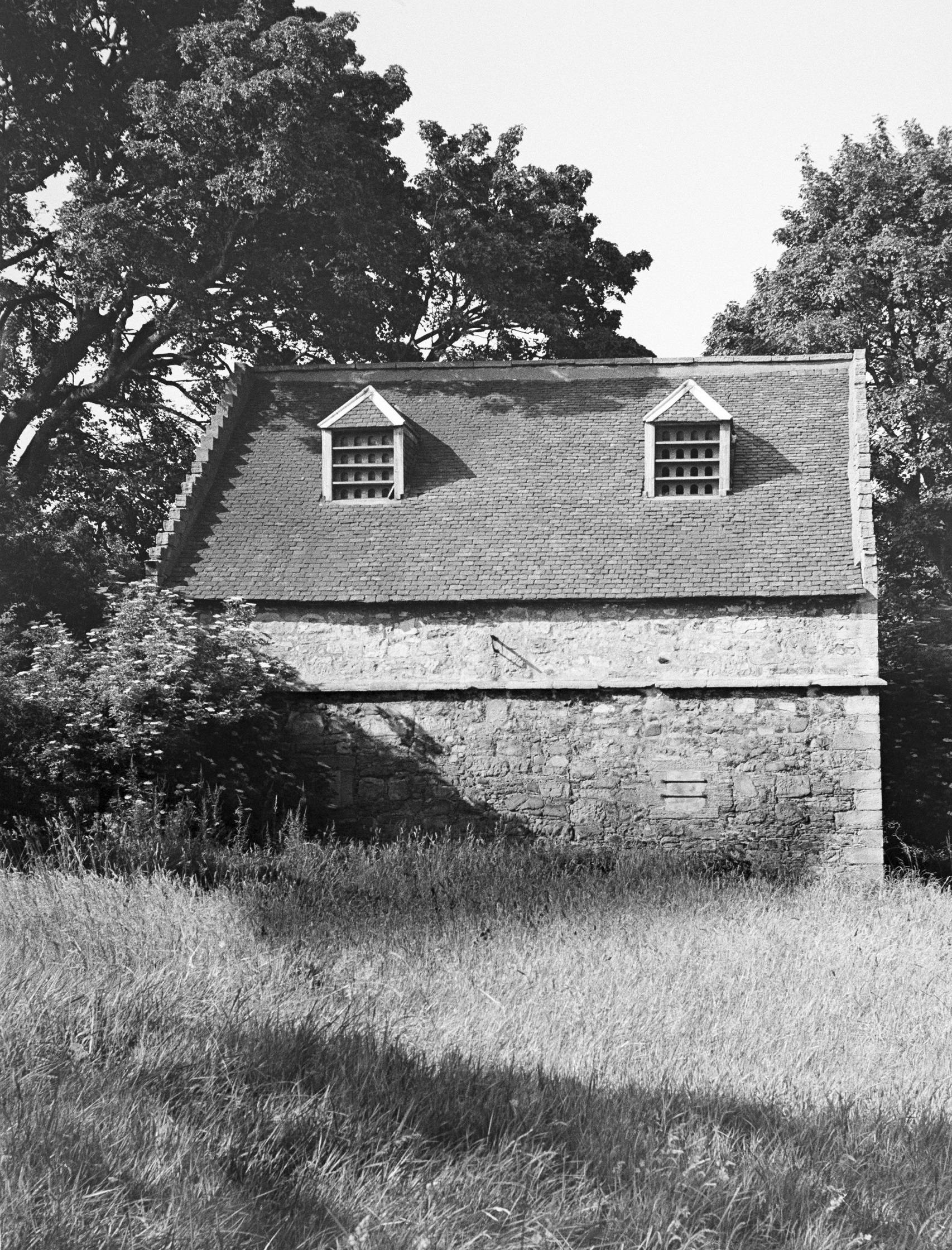 Black and white archive photo of a rectangle doocot with two small windows. 