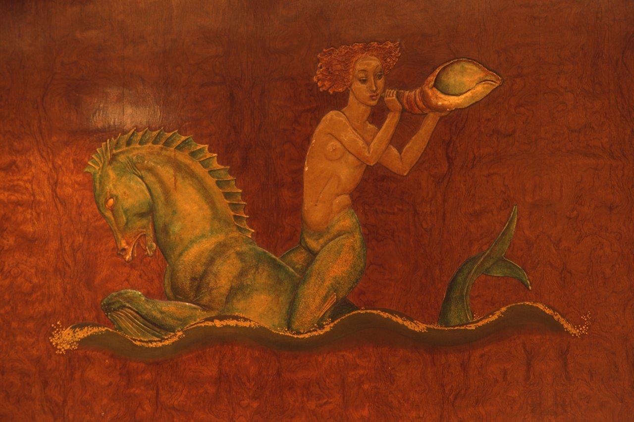 Photo of the colourful an intricate design of a naked mermaid on a seahorse. She's also holding a shell
