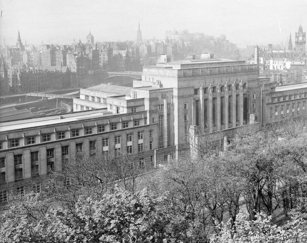 Black and white archive photo of St Andrews House. It's very symmetrical and impressive. You can see the Edinburgh cityscape in the background.