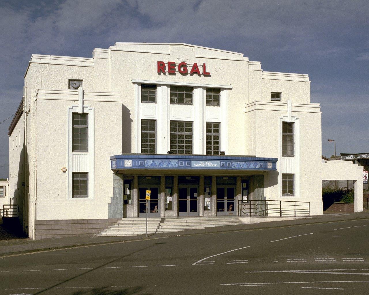 The cream coloured exterior of the Regal cinema. It has Regal written in bold red letters at the top