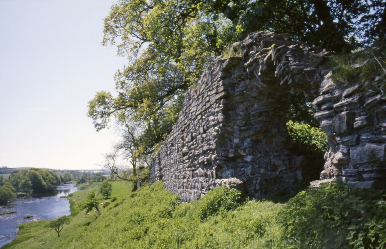 ruined stone wall on a grassy hill
