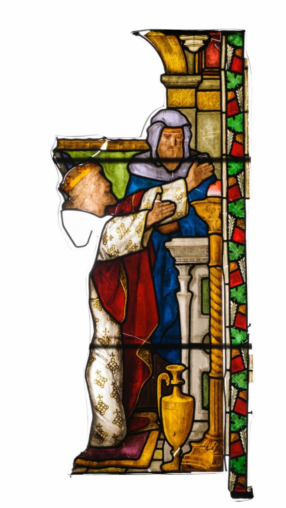 Stained glass fragment. A man wearing a crown kneels at an alter with his arms upraised. Another man in blue robes stands beside him watching.