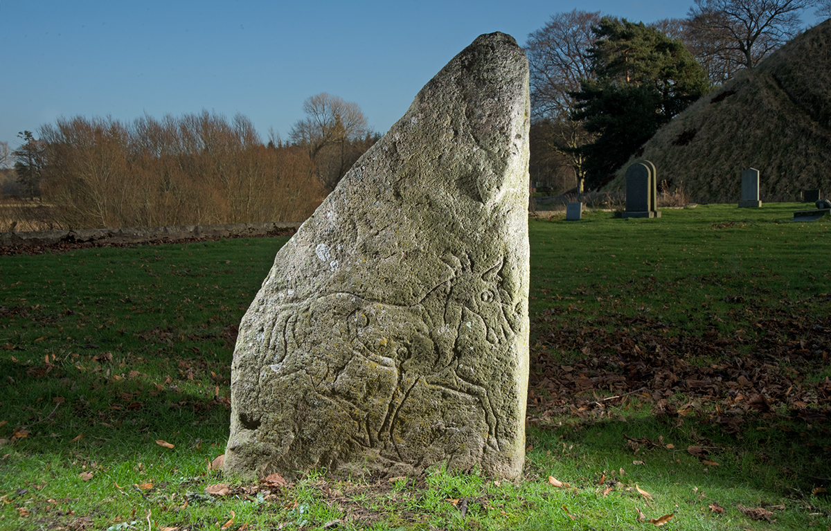triangular stone with a depiction of a horse carved on it.