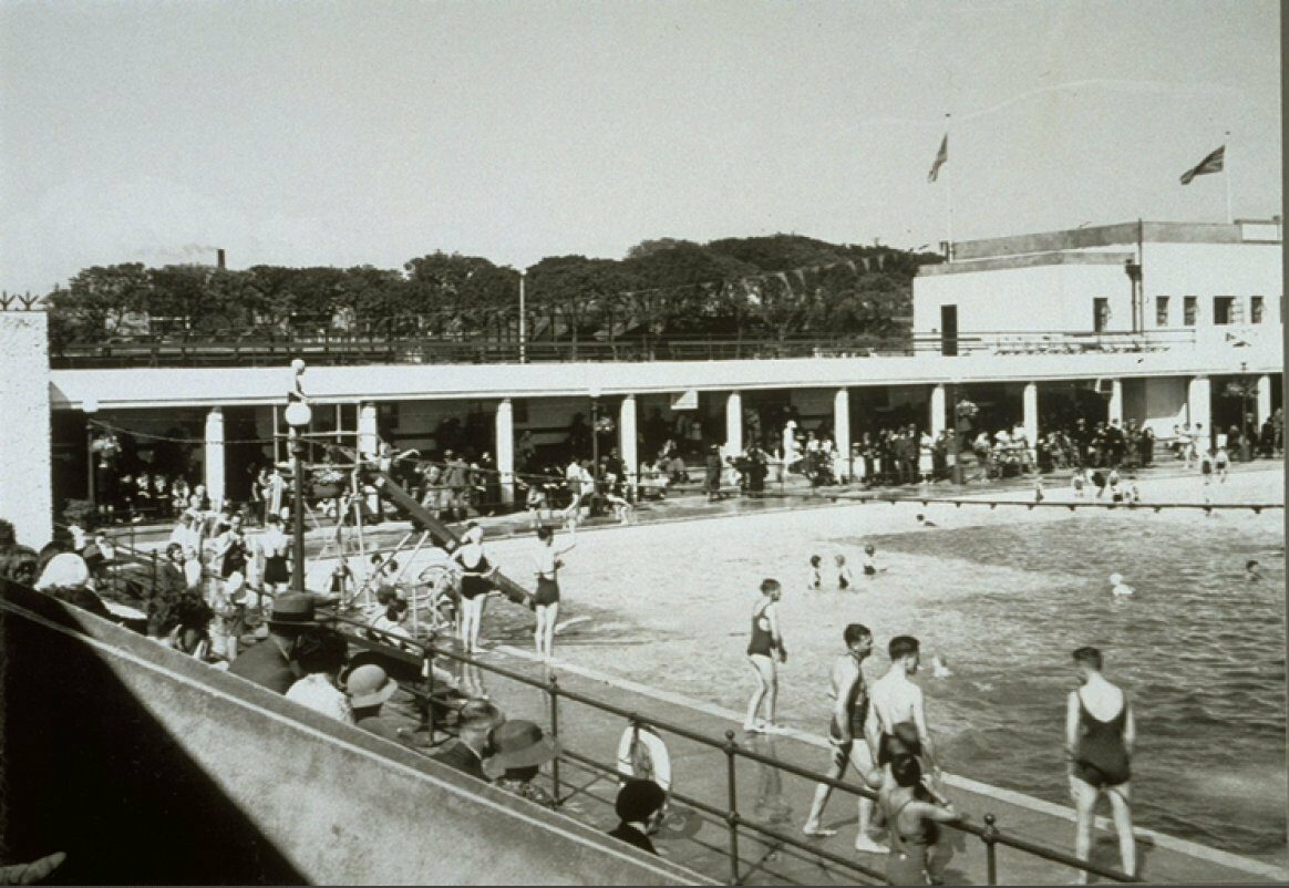 Black and white archive photo showing groups of people at an open air swimming pool