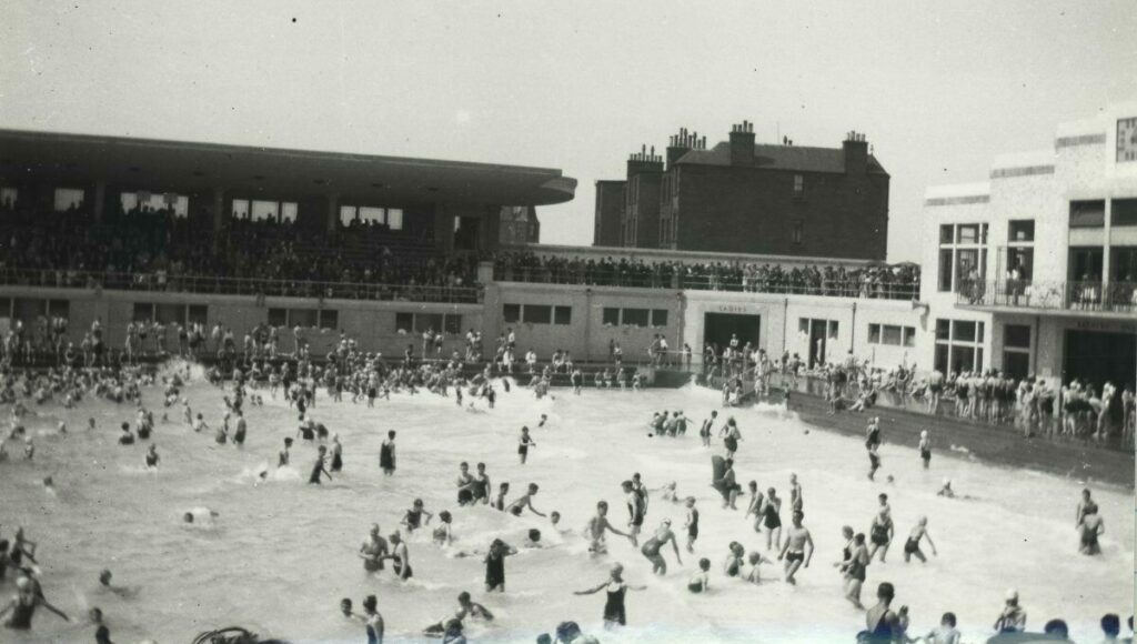 A black and white archive photo of the inside of Portobello pool with people bathing in the wave pool