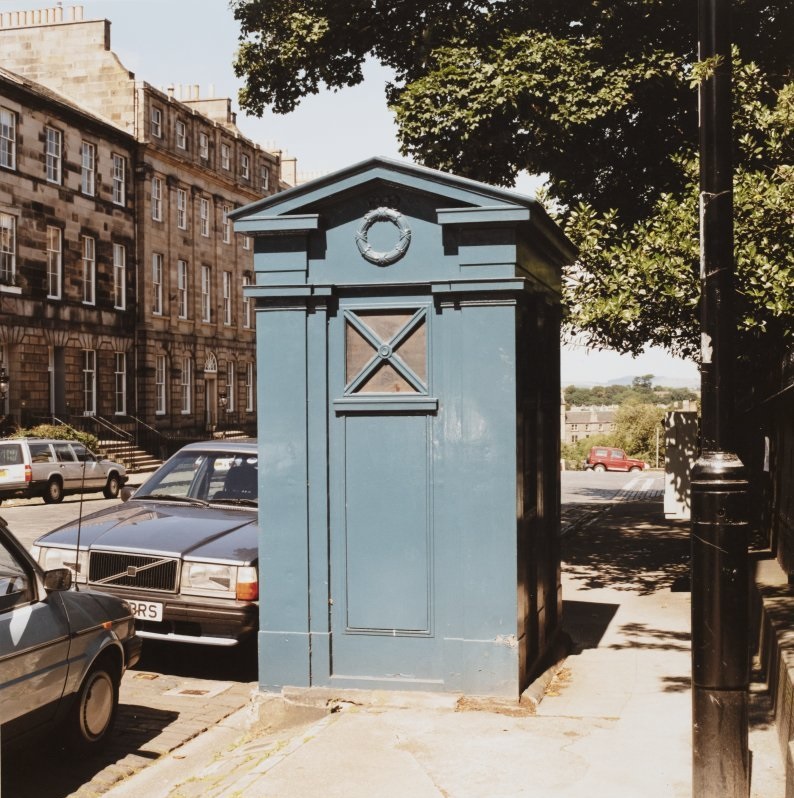 A blue police box in a urban setting.