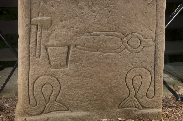stone with images of hammer, anvil and tongs engraved on it