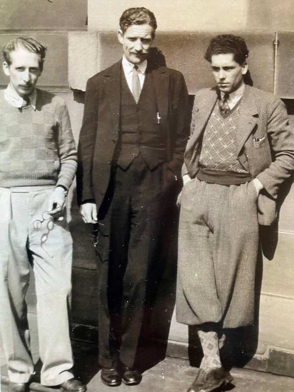 Three men standing facing the camera, none of them are smiling.