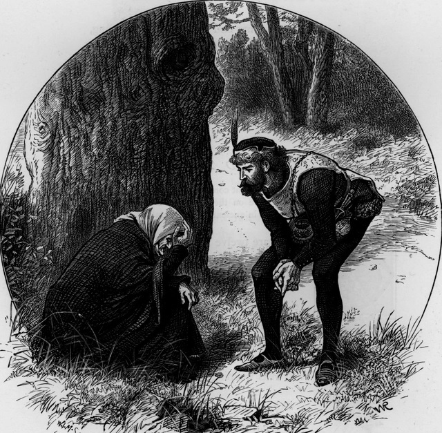 Black‑and‑white illustration of Robin Hood bending down to speak to a poor beggar woman who sits on the ground beside a large tree. Robin Hood is dressed in medieval clothing with a feathered cap, while the woman is wrapped in a hooded cloak. They are in a woodland setting with grass and trees surrounding them.