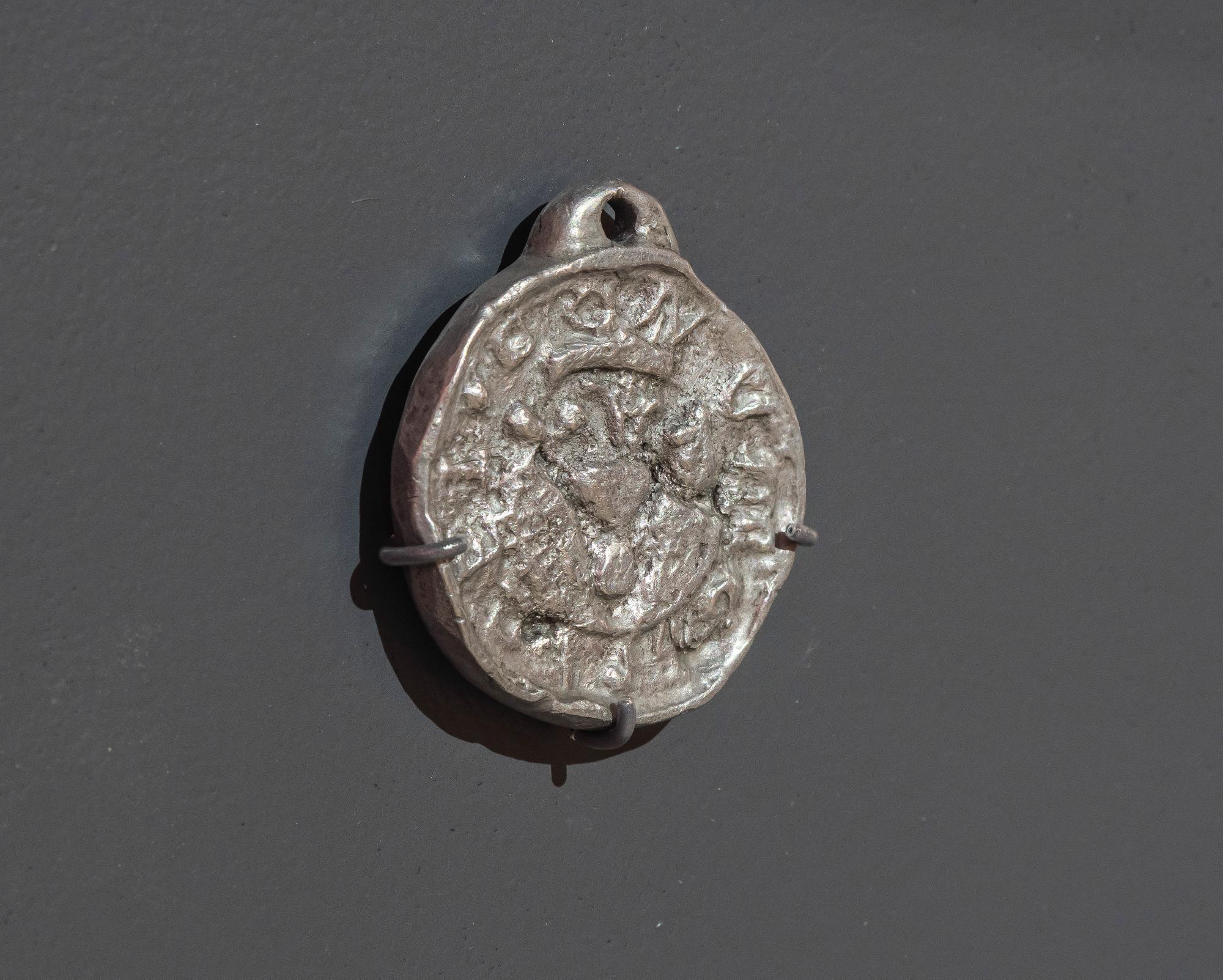 Beggar's badge against a grey background.