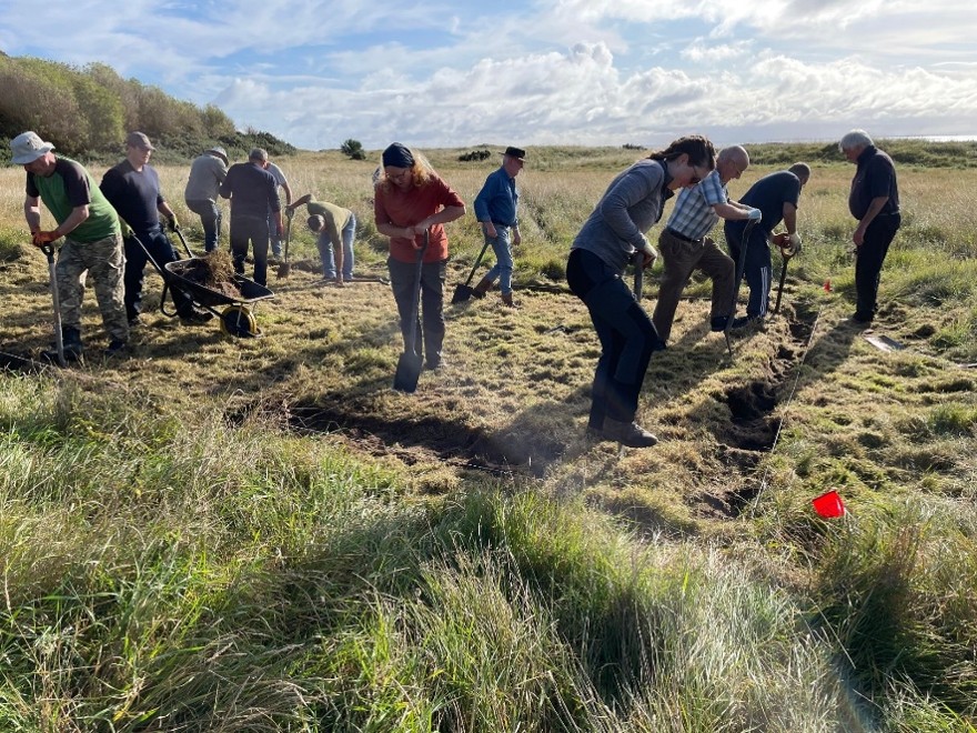 People starting an archaeological excavation in a field. 
