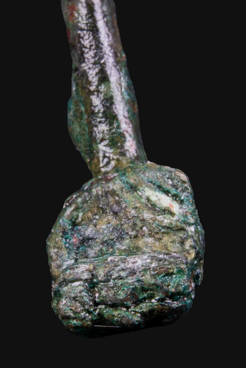 Detail of a hand pin against a black background.