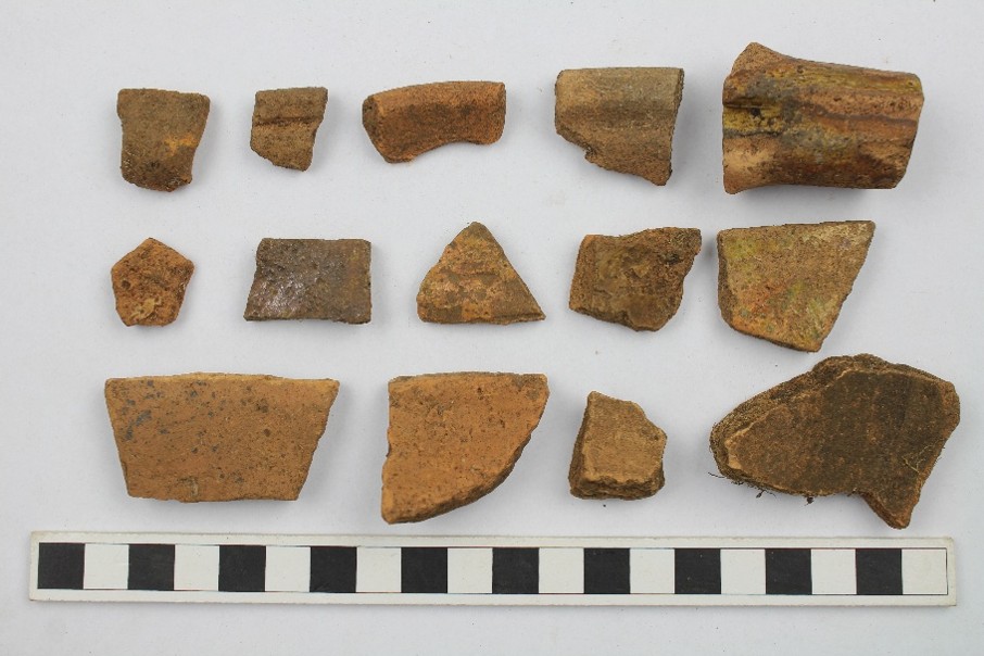 Medieval redware laid out on a white surface.